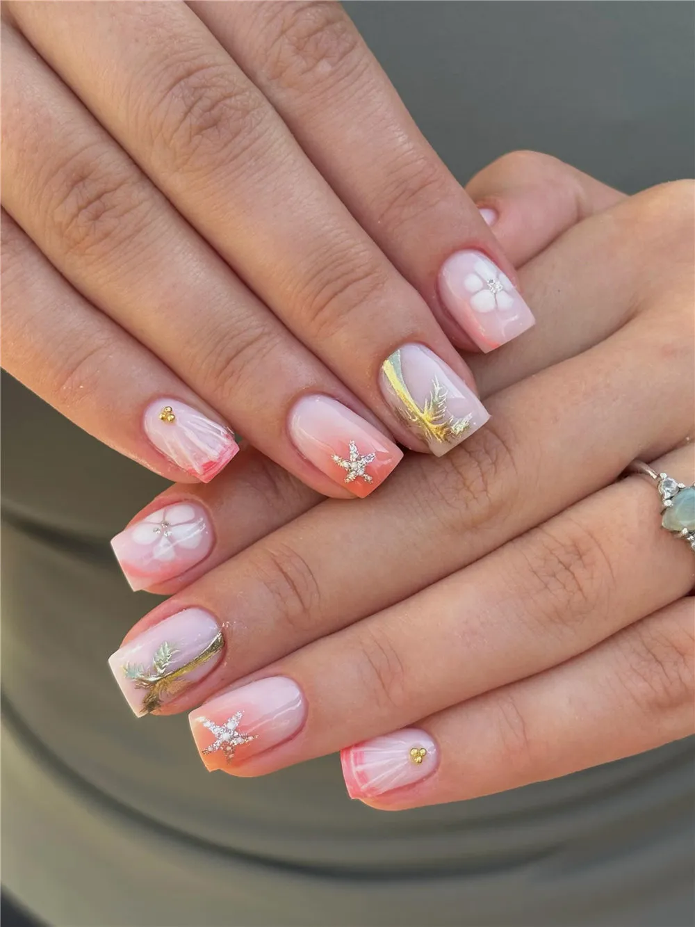 Pink and white square 3D ocean nails with shells, starfish, and gold accents