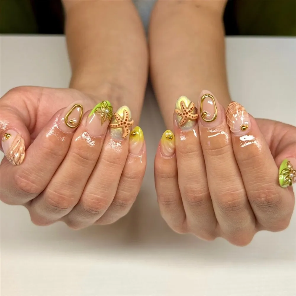 Short 3D starfish nails with shell accents, yellow tips, and gold outlines