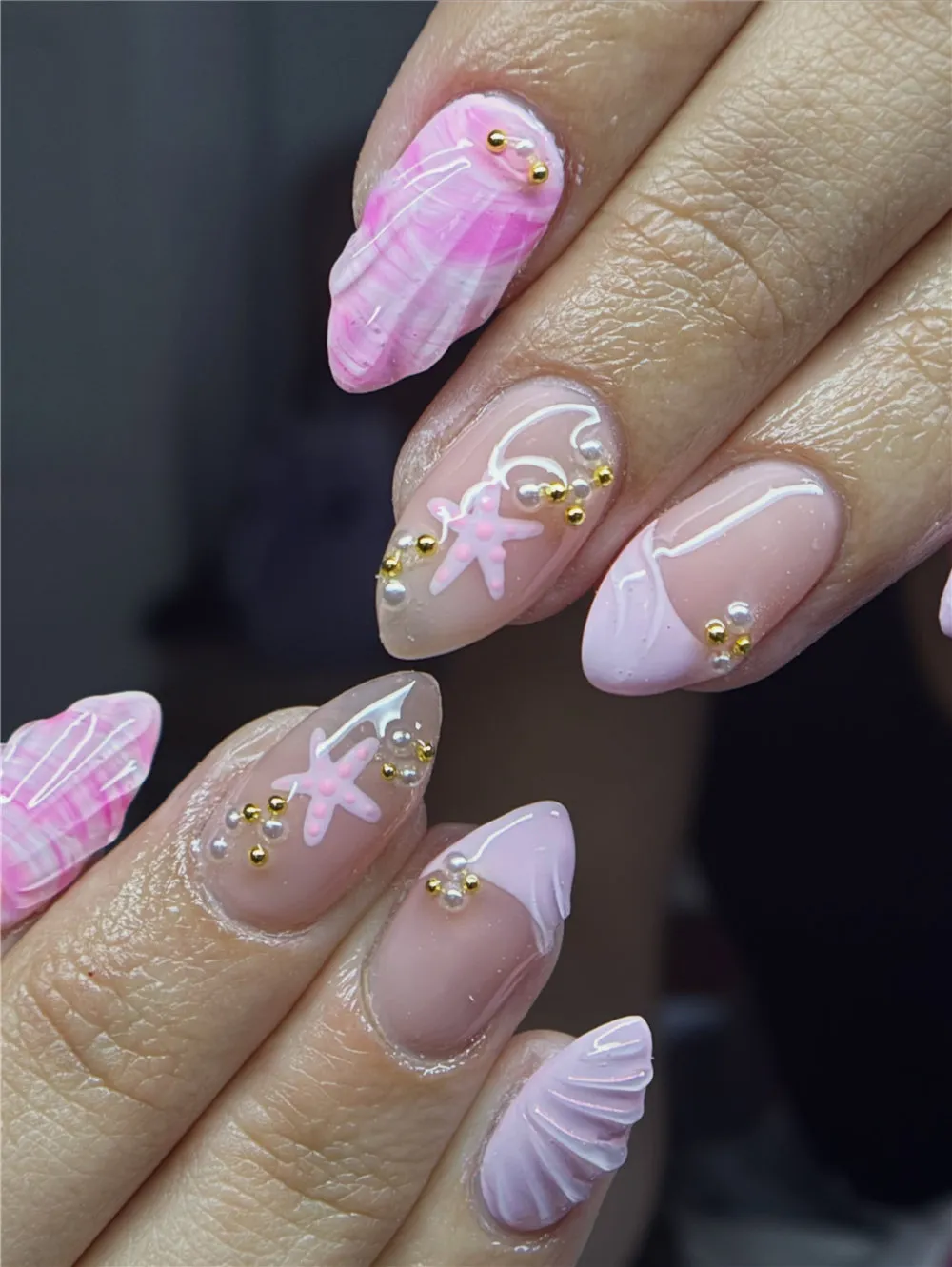 Pink almond 3D shell nails with starfish, pearls, white lines, and gold beads