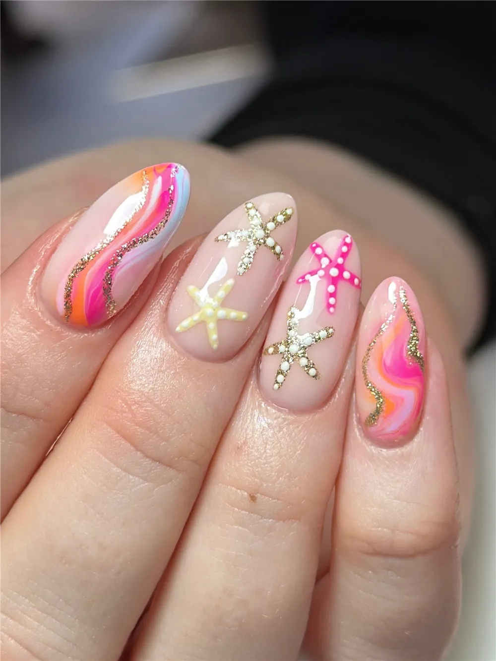 Pink and coral wave ocean nails with glitter lines and raised starfish accents