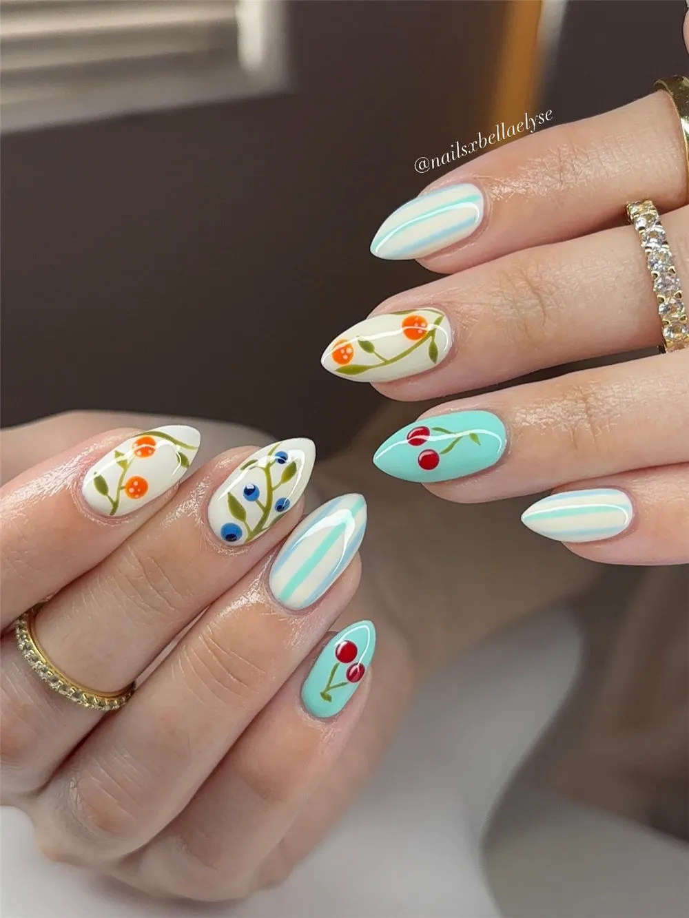 White and aqua almond nails with fruit accents and striped summer nail art