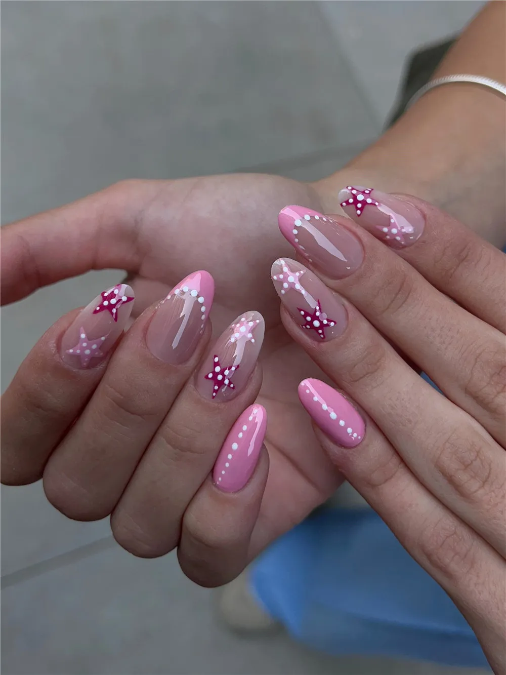 Long almond pink nails with magenta starfish and white dotted trail nail art