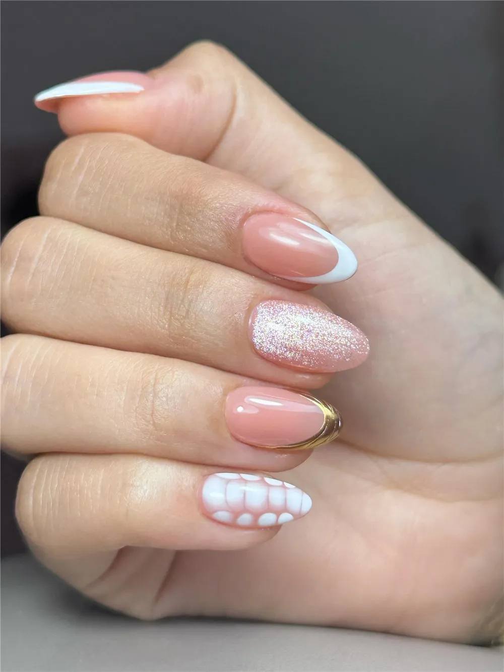 Almond white French nails with pink glitter, gold accent, and white scale nail art